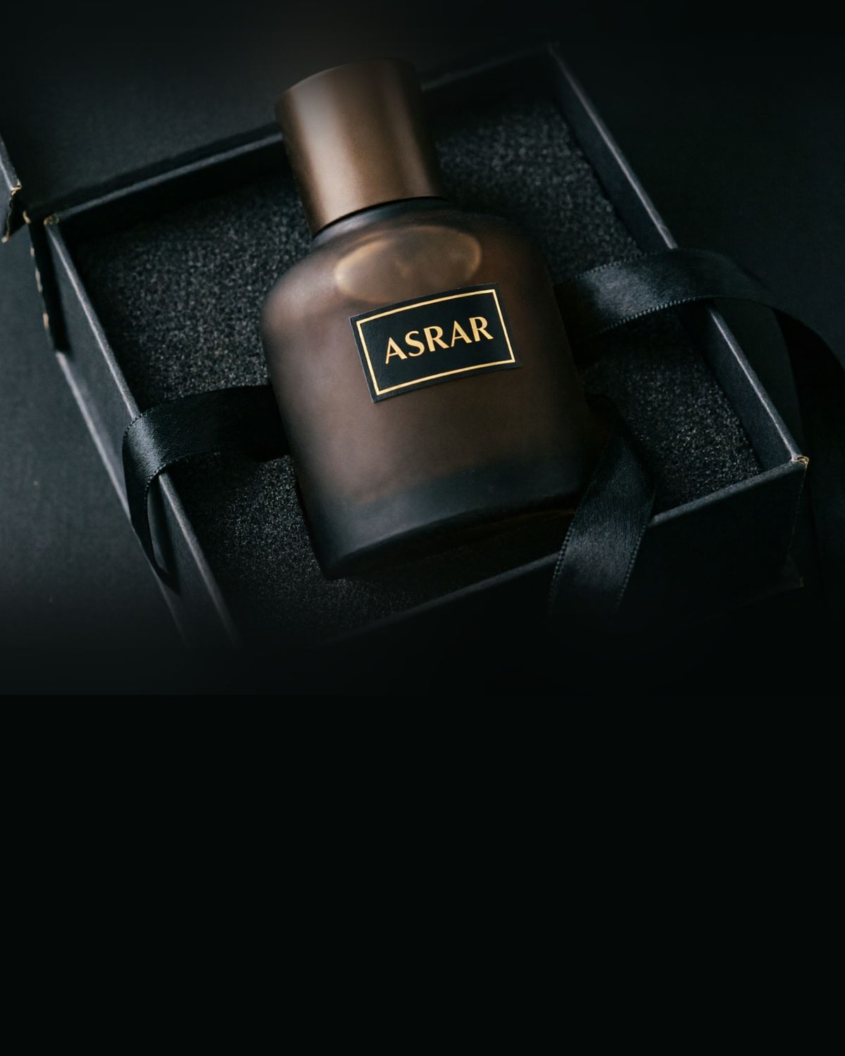 A perfume bottle resting in an open black gift box
